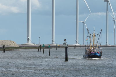 Boat on lake by windmills