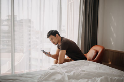 Young woman using laptop on bed at home