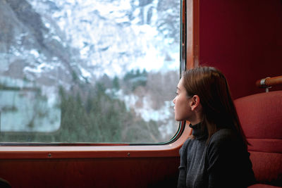 Woman looking away through train window