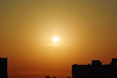 Silhouette buildings against sky during sunset