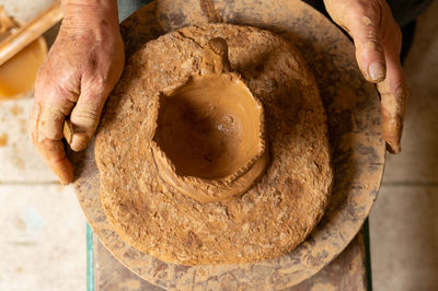 Close-up of person preparing food in mud