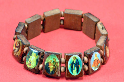 Close-up of religious bracelet on red background