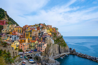 Buildings by sea against sky