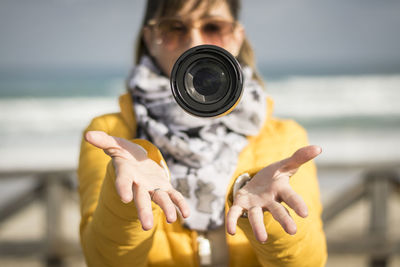 Close-up of woman with camera lens in mid-air