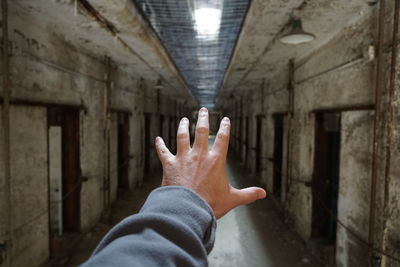 Cropped hand of man gesturing in corridor