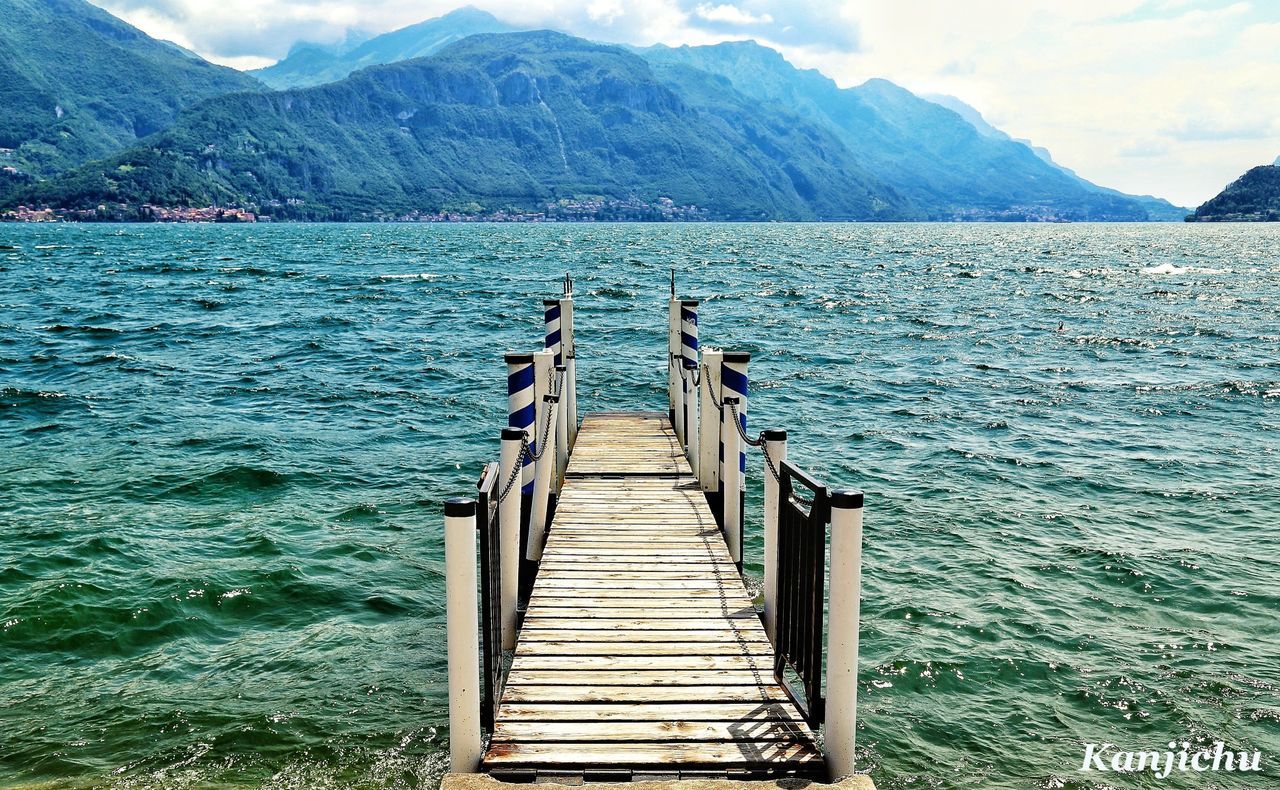 water, mountain, tranquil scene, pier, tranquility, scenics, mountain range, beauty in nature, lake, nature, wood - material, sky, sea, jetty, railing, idyllic, rippled, built structure, non-urban scene, day