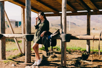 Full length of woman standing by stable