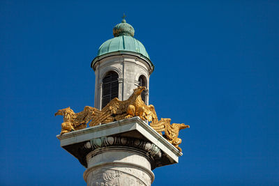 Low angle view of statue of building against blue sky