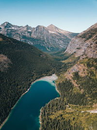 Scenic view of lake and mountains against clear blue sky