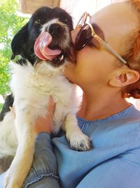 Close-up of woman with dog sitting outdoors