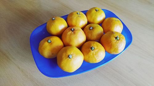 High angle view of orange fruits in plate on table
