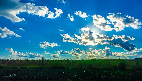 Scenic view of field against cloudy sky