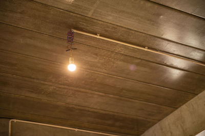 Low angle view of light bulb hanging on ceiling