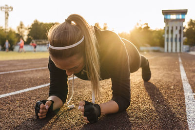 Full length of woman exercising in stadium