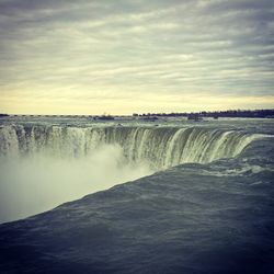 Scenic view of waterfall against sky