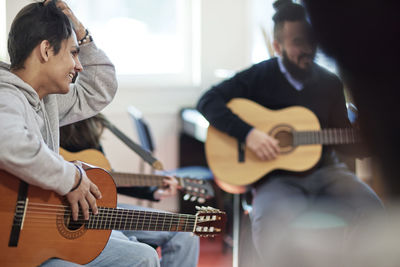 Teenagers attending guitar lesson