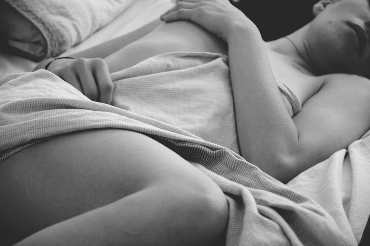 CLOSE-UP OF MIDSECTION OF WOMAN WITH BED