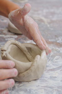 Cropped hands kneading clay