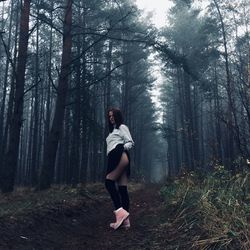 Full length of woman standing in forest