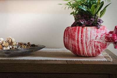 Close-up of red berries on table against wall