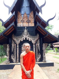 Portrait of man standing outside temple against building