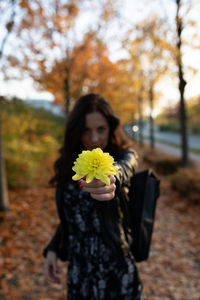 Beautiful young woman standing by flower tree