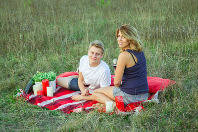 Woman sitting on grassy field