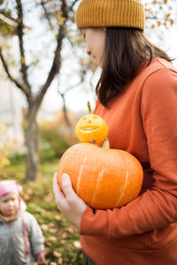 Midsection of woman with pumpkins in pumpkin during halloween