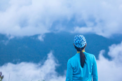 Rear view of man looking at mountain against sky
