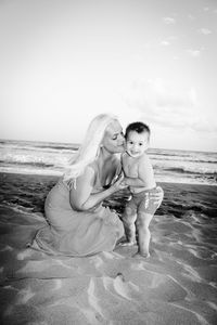 Mother kissing son at beach