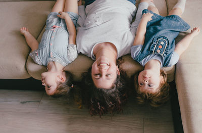 High angle view of siblings lying on floor