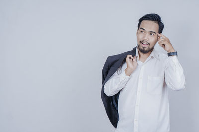 Young man standing against white background