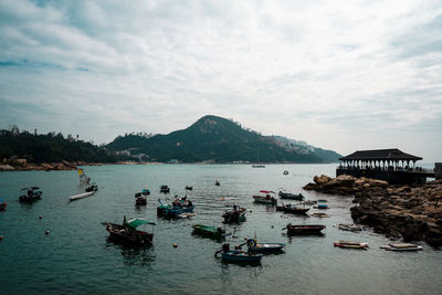 View of boats in sea against cloudy sky
