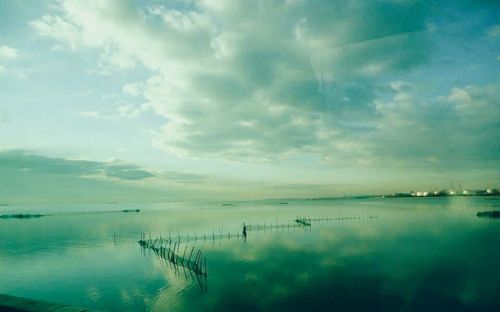 Scenic view of calm sea against cloudy sky