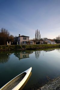 Scenic view of lake by building against sky