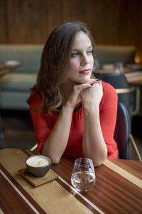 Beautiful young woman having coffee at cafe