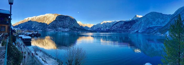 Scenic view of lake and mountains against blue sky