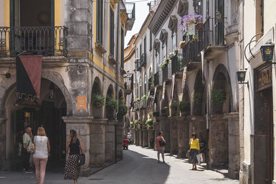 People walking on street amidst buildings in city