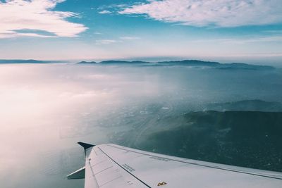 Airplane flying over sea against sky