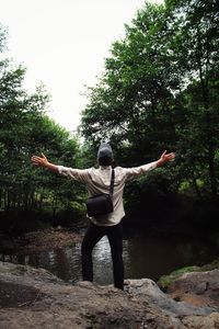 Rear view of senior man standing by plants