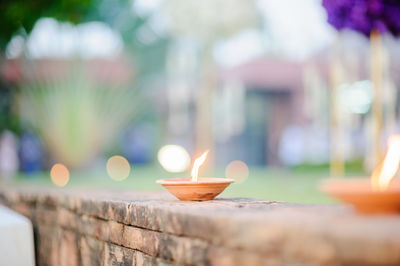 Close-up of lit candles on retaining wall