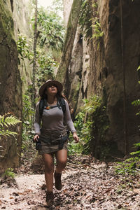 Young woman exploring a canyon with action camera and gps.