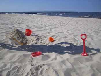 Shovel and containers on sandy beach