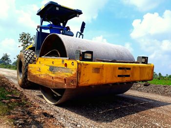 Yellow cart on road amidst field