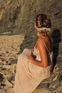 Rear view of woman sitting on beach