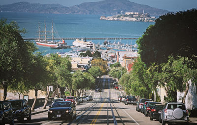 Cars on road by city against sky