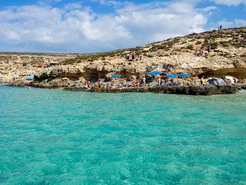 Scenic view of blue lagoon at comino island against sky