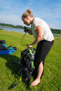 Scuba diver demonstrating oxygen mask on grassy field by lake