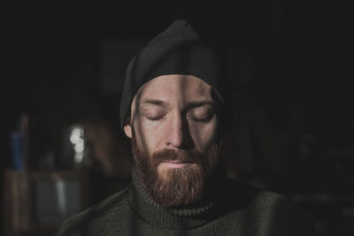 Bearded young man with eyes closed at home