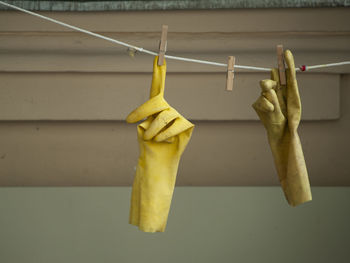 Close-up of clothes hanging on rope against wall